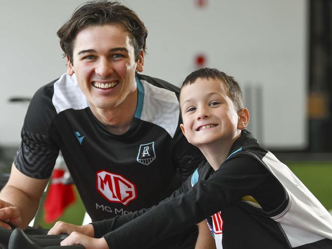 Xavier Pudovkin, 6, is a massive Port fan and is currently battling cancer tries out the exercise  bikes with Connor Rozee of the Power in their indoor training centre .Wednesday,September,11,2024.Picture Mark Brake