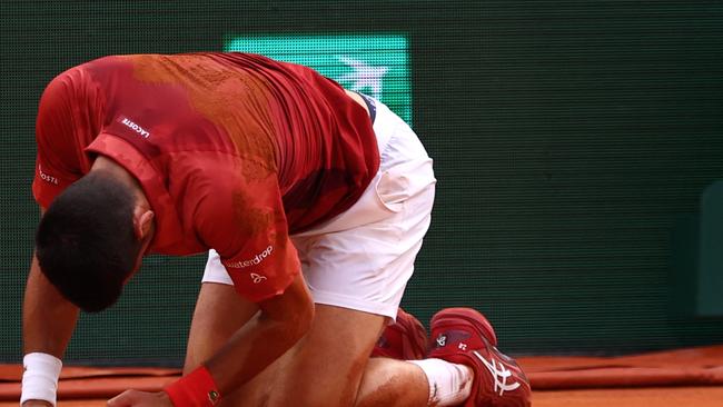 TOPSHOT - Serbia's Novak Djokovic reacts after falling on the court during his men's singles round of sixteen match against Argentina's Francisco Cerundolo on Court Philippe-Chatrier on day nine of the French Open tennis tournament at the Roland Garros Complex in Paris on June 3, 2024. (Photo by Emmanuel Dunand / AFP)