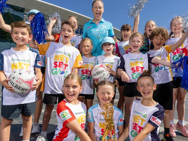 Mavericks player Kim Jenner with young netballers and the super netball trophy for story about Melbourne scoring the final game at Rod Laver and sparking hopes it will set a new netball crowd record. Picture: Jason Edwards