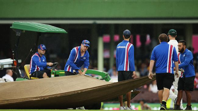 Groundsman cover the pitch during a rain delay on Day 2 of the 3rd cricket Test match between Australia and the West Indies at the SCG. Pic Brett Costello