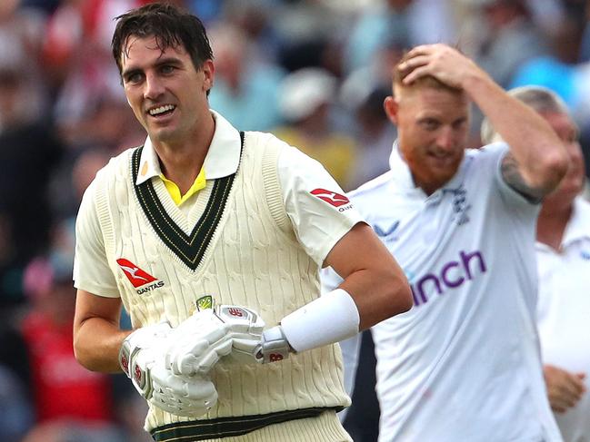 Pat Cummins celebrates winning the first Ashes Test with Ben Stokes in the background. Picture: Geoff Caddick / AFP