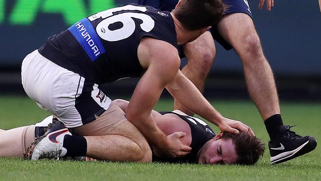 Teammates and trainers rush to Jed Lamb after an off-the-ball incident with Richmond’s Bachar Houli. Picture: Michael Klein