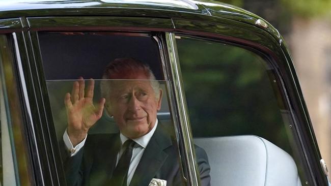 Britain's King Charles III waves to the crowds after leaving Clarence House ahead of the ceremonial procession of the coffin of Queen Elizabeth II from Buckingham Palace to Westminster Hall. (Photo by Stefan Rousseau / POOL / AFP)