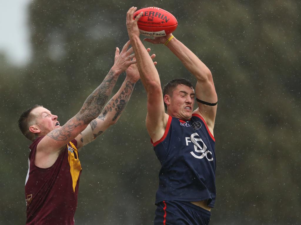 Rain pours down as Springvale Districts’ Matt Wetering reels in a contested mark. Picture: Stuart Milligan