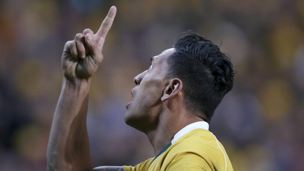 Israel Folau points to the sky after scoring a try against England.