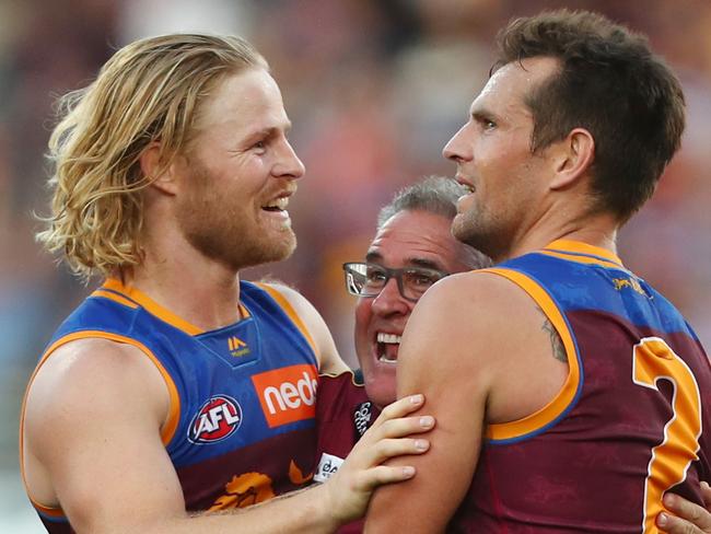 BRISBANE, AUSTRALIA - AUGUST 17: Lions coach Chris Fagan celebrates with players Daniel Rich and Luke Hodge after winning the round 22 AFL match between the Brisbane Lions and the Geelong Cats at The Gabba on August 17, 2019 in Brisbane, Australia. (Photo by Chris Hyde/Getty Images)