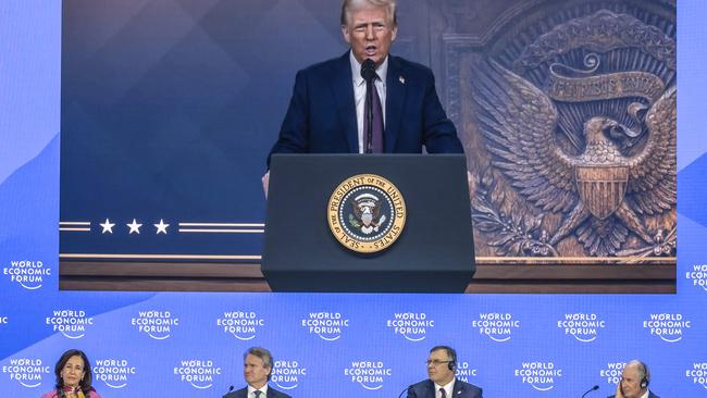 US president Donald Trump appears on a giant screen as he adresses Donald Trump global elites via video conference at the World Economic Forum in Davos on January 23, 2025. (Photo by Fabrice COFFRINI / AFP)