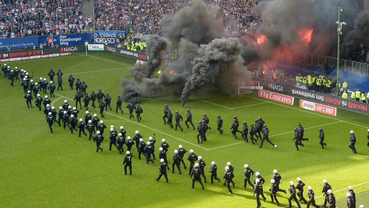Policemen run onto the pitch as fireworks were thrown ahead the final whistle which sealed Hamburger SV’s relegation from the Bundesliga.