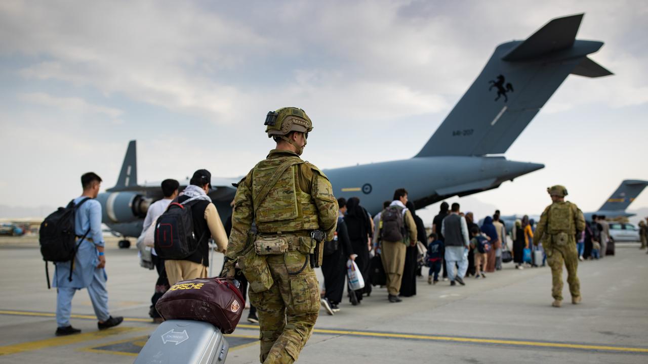 Australian citizens and visa holders prepare to board the Royal Australian Air Force C-17A Globemaster III aircraft, as Australian Army infantry personnel provide security and assist with cargo at Hamid Karzai International Airport, Kabul.