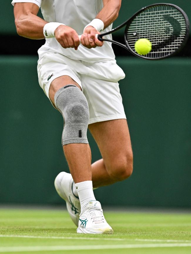 The bandaged knee of Serbia's Novak Djokovic as he returns the ball to Czech Republic's Vit Kopriva during their men's singles tennis match on the second day of the 2024 Wimbledon Championships.