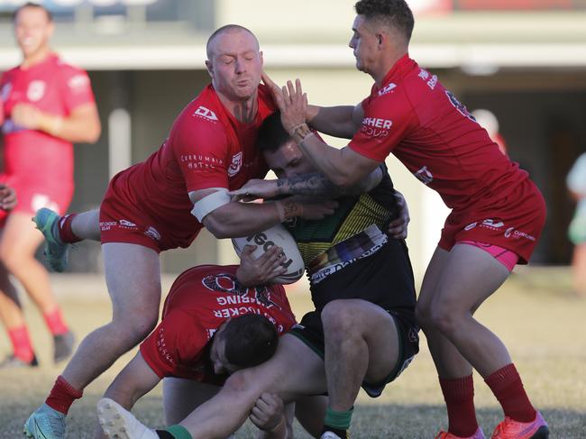 Luc Lyndon, Jarrod Gill and Tahne Robinson of Currumbin Eagles lay a tackle. Photo: Regi Varghese