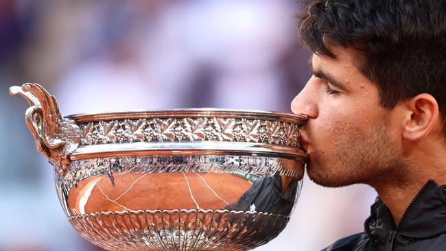 Spain's Carlos Alcaraz kisses the trophy after winning against Germany's Alexander Zverev in the men's singles final match on Court Philippe-Chatrier on day fifteen of the French Open tennis tournament at the Roland Garros Complex in Paris on June 9, 2024. (Photo by EMMANUEL DUNAND / AFP)