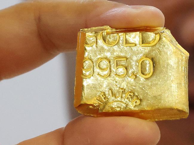 A jeweller displays a bar of gold at his shop in Kuwait City on October 21, 2024. (Photo by YASSER AL-ZAYYAT / AFP)