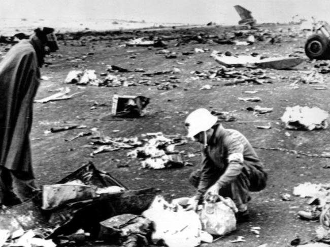 A Spanish civil guard with a Red Cross official search through debris for victims personal belongings after the fatal crash collision between KLM Boeing 747 and Pam Am 747 aeroplanes at Tenerife in the Canary Islands, Spain in 1977. Picture: Supplied.