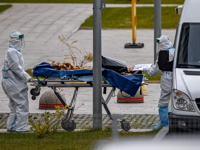 Medical staff members carry a person on a stretcher at the Covid-19 infected patients section at the Kommunarka Hospital outside Moscow on October 15, 2021. - Russia on October 15, has hit record of daily coronavirus deaths and infections, with 32,196 new cases and 999 death, registered across the country over the past 24 hours. (Photo by Dimitar DILKOFF / AFP)