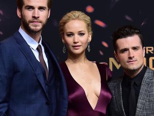 (From L) Australian actor Liam Hemsworth, US actress Jennifer Lawrence, and US actor Josh Hutcherson pose for photographers on the red carpet as they arrive for the world premiere of the movie "The Hunger Games: Mockingjay — Part 2", in Berlin on November 4, 2015. AFP PHOTO / JOHN MACDOUGALL