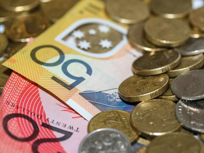 Close up of Australian money, twenty and fifty dollar notes and gold and silver coins scattered on pile.