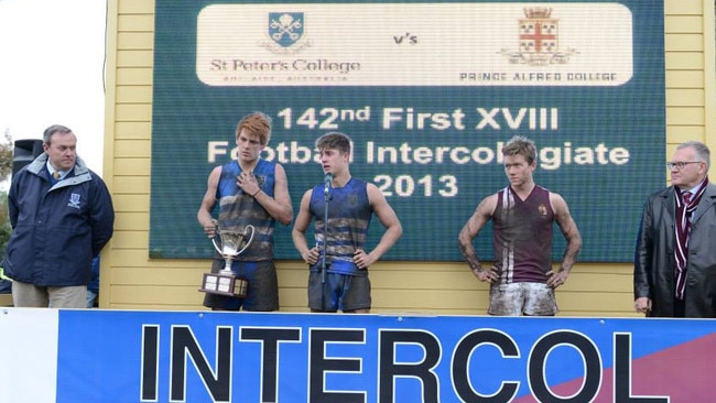 Victorious St Peter’s co-captains Mitch Harvey and Riley Knight with the intercol footy trophy in 2013, alongside Prince Alfred skipper Campbell Combe. Picture: St Peter's College