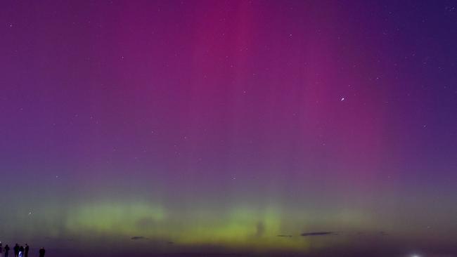 People watch the aurora australis or southern lights caused by a solar storm at Port Phillip Bay in Melbourne. Picture: Paul Crock / AFP