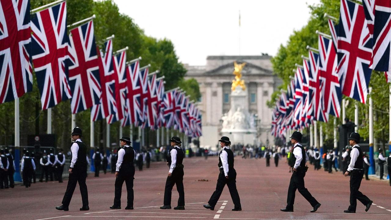 Police officers patrol along the Mall ahead of the procession. (Photo by Victoria Jones / POOL / AFP)