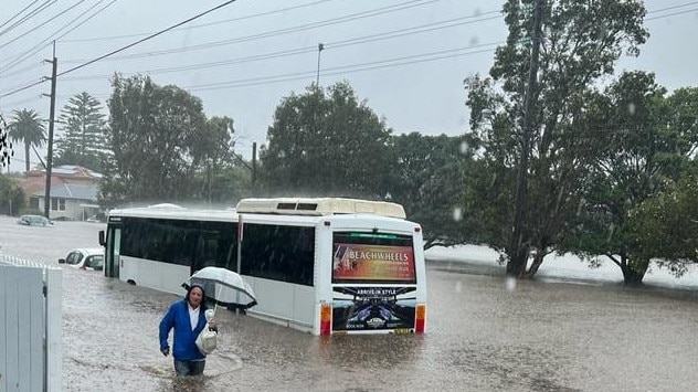 A resident makes their way along flooded Pittwater Rd at North Manly after the thunderstorm on Wednesday, March 8, 2022. More than 260 homes have already reported flood damage. Picture: Marianne Bray