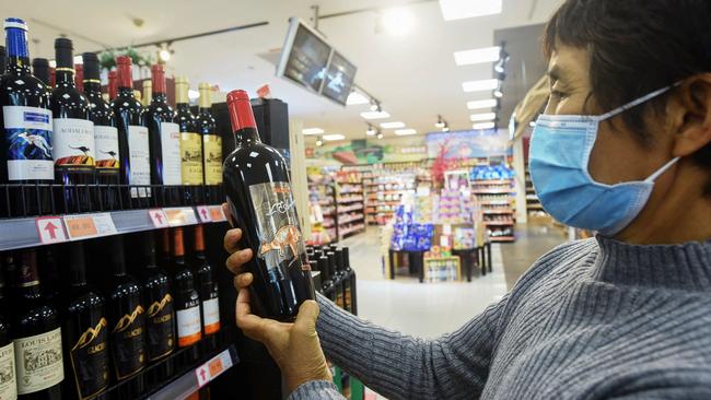 A woman looks at a bottle of Australian wine at a supermarket in Hangzhou, in eastern China's Zhejiang province last Friday. Picture: AFP