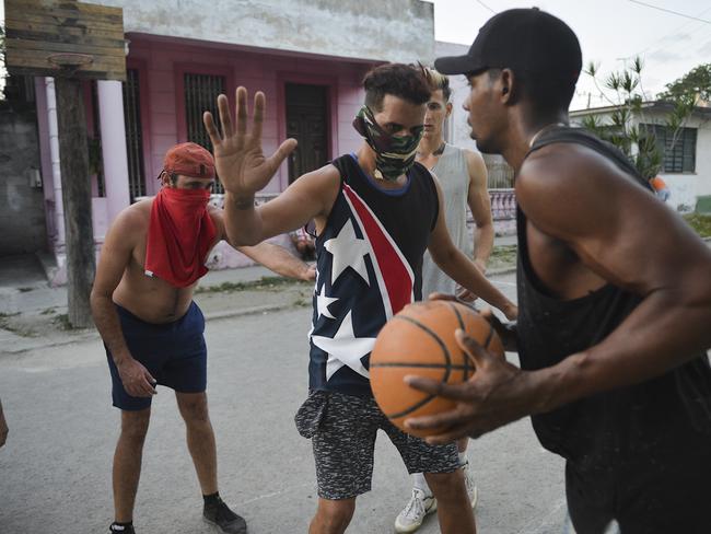 Cuban men play basketball on the street while wearing protective face masks. Picture: AFP