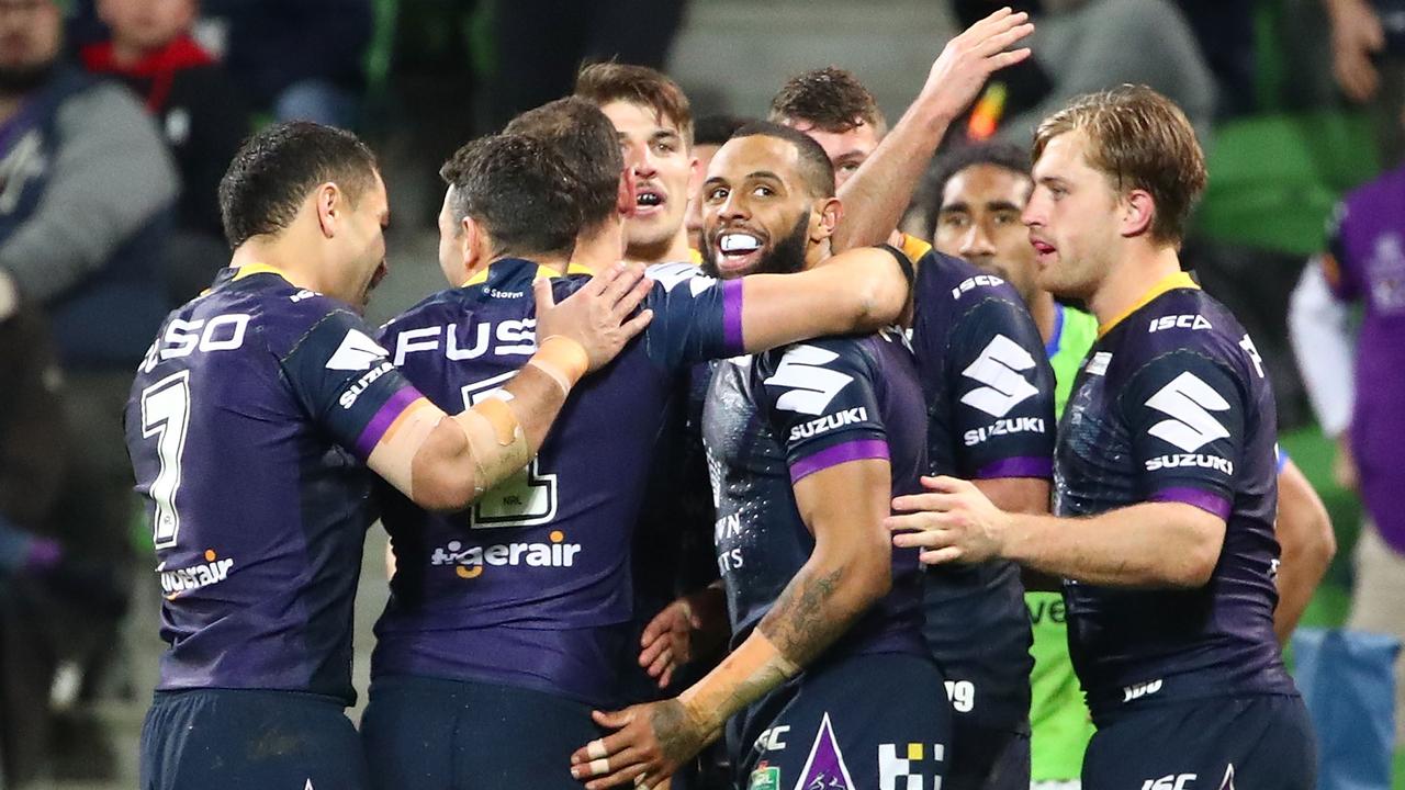 Josh Addo-Carr of the Melbourne Storm is congratulated by his teammates.