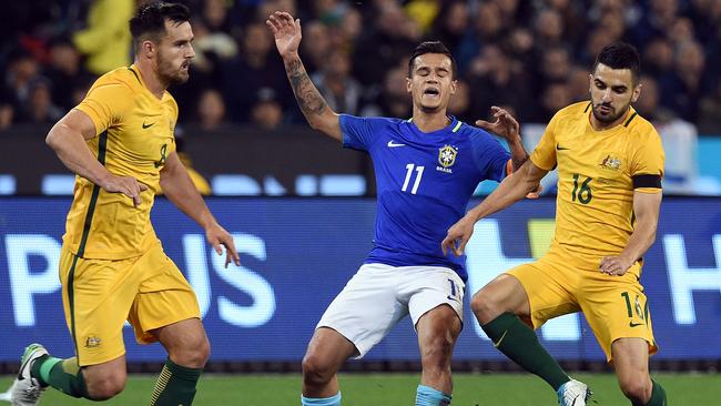 Australia's Bailey Wright (R) and Aziz Behich (L) fight for the ball with Philippe Coutinho.