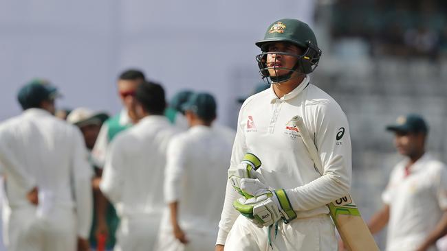 Australia's Usman Khawaja, foreground, walks back to the pavilion after his dismissal.