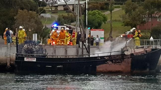 Firefighters extinguishing a fishing boat towed to Kettering after it caught fire near Port Arthur. Picture: SUPPLIED