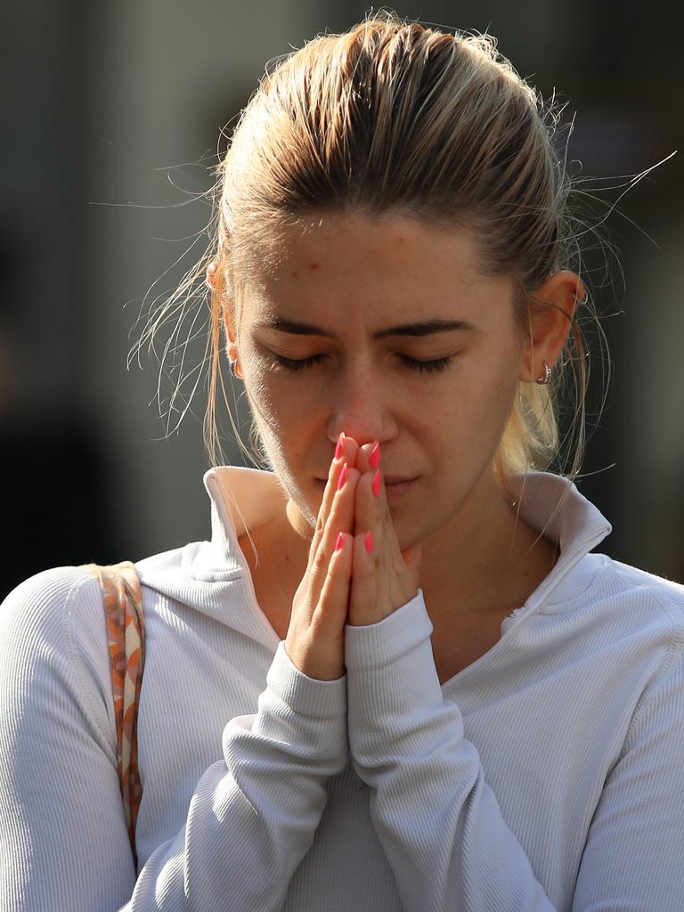 A member of the public prays at a flower tribute area at the edge of Westfield Bondi Junction. Picture: Lisa Maree Williams/Getty Images