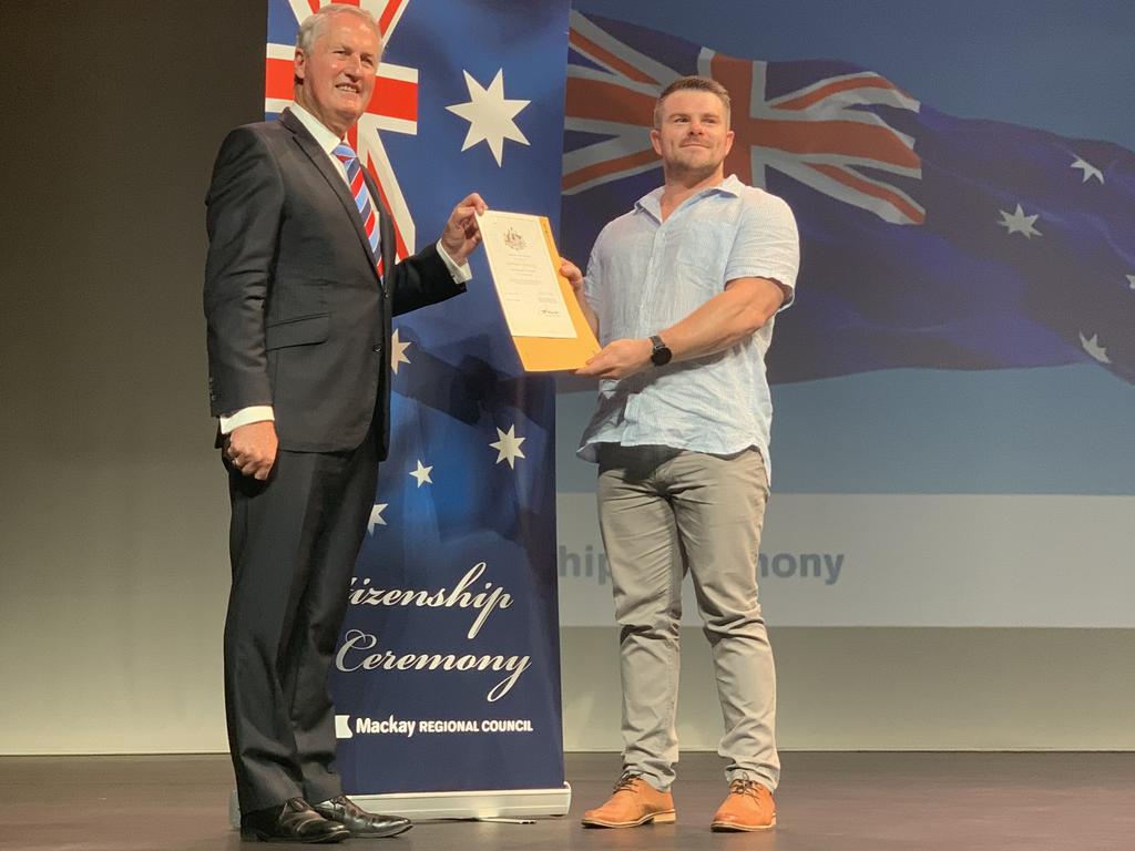 Ryan Flannigan, from Scotland, receives his certificate of citizenship from Mackay Mayor Greg Williamson at the MECC. Wednesday, January 26, 2022. Mackay Australia Day 2022. Mackay Citizenship Ceremony 2022. Picture: Duncan Evans
