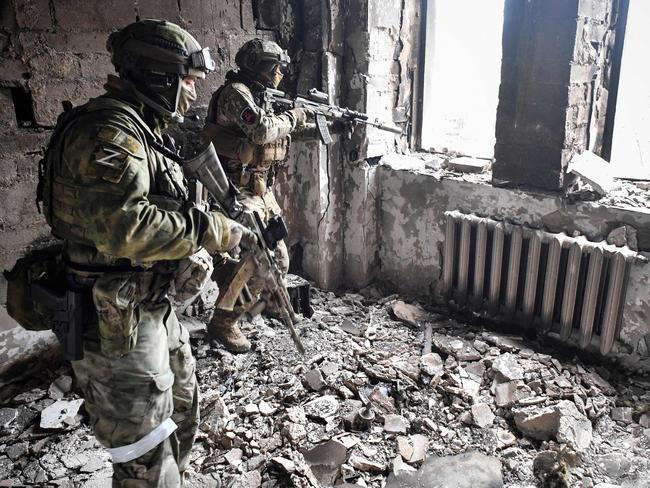 Two Russian soldiers patrol the Mariupol drama theatre, which was bombed on March 16. Picture: AFP