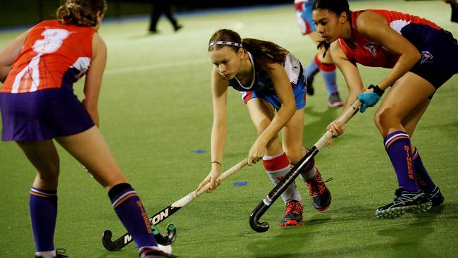 Cairns Hockey Association A-grade women’s match between Saints and Trinity Stingers. Saints Sophie Glover takes on Stingers’ Kaitlyn Broad and Sophie Gilligan. PICTURE: STEWART MCLEAN