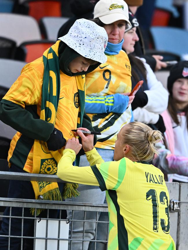 Tameka Yallop signs a more traditional Aussie jersey. (Photo by Maria Lysaker/Getty Images)