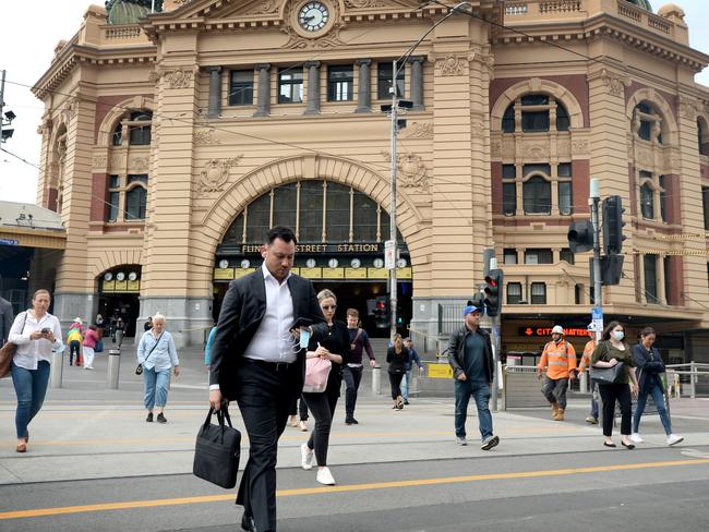 MELBOURNE, AUSTRALIA - NewsWire Photos JANUARY 18, 2021: Morning commuters outside Flinders Street Station on the first day where 50% of workers can safely return to the office. Picture: NCA NewsWire / Andrew Henshaw