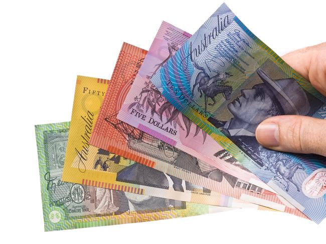 Young hand holding a fan of colorful Australian money.