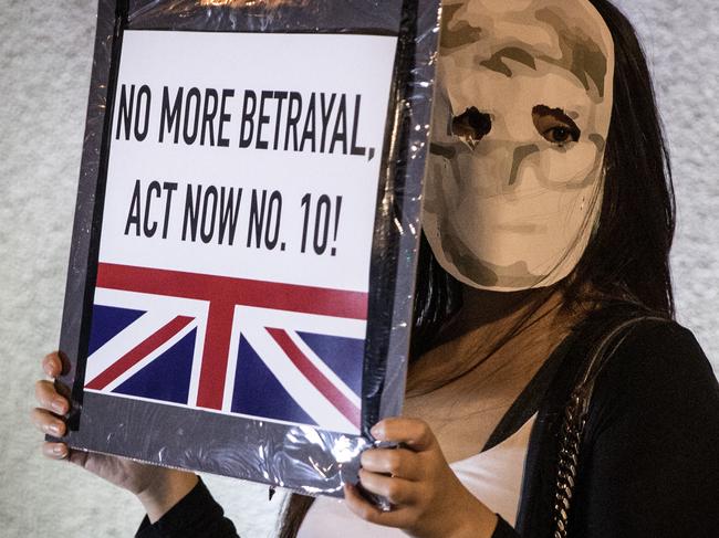 Protesters wear a mask featuring the face of former UK Consulate employee Simon Cheung during a petition protest outside the British Consulate General in Hong Kong. Picture: Getty