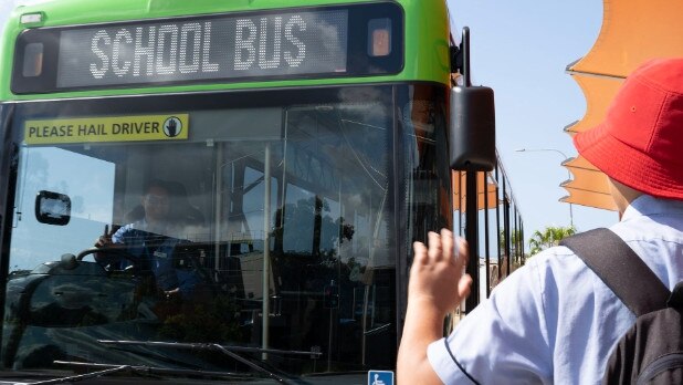 A student waves down a school bus on the Gold Coast.