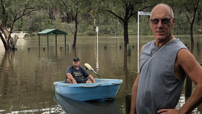 Steve McDonald and Darren Mercer are using a boat and canoe to transport his neighbours. Picture: Lawrence Machado