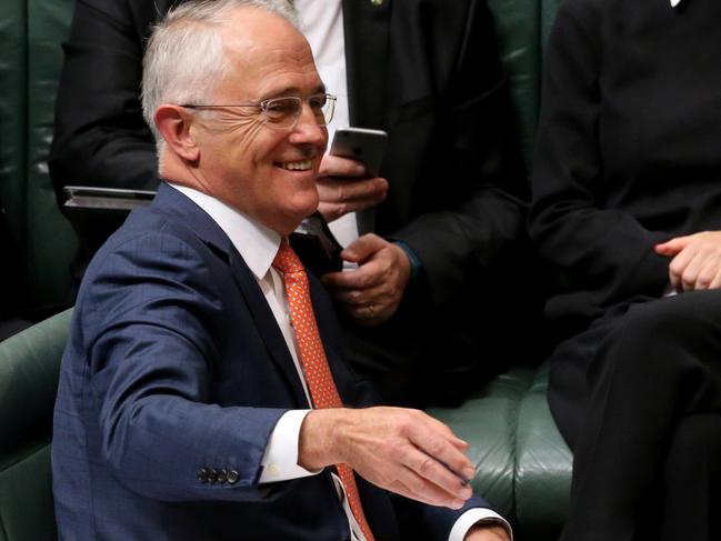 PM Turnbull laughs as Shadow Treasurer Chris Bowen holds up a newspaper story during Question Time in the House of Representatives Chamber at Parliament House in Canberra. Picture Ray Strange