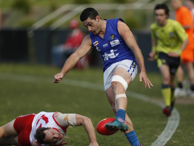 Karingal’s Scott Jansen goes to ground as Luke Hewitt takes a kick. Picture: Valeriu Campan