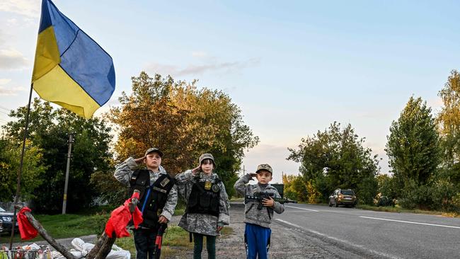 Ukrainian children salute while holding toy rifles as they man an improvised checkpoint the Donetsk region of Ukraine. Picture: AFP