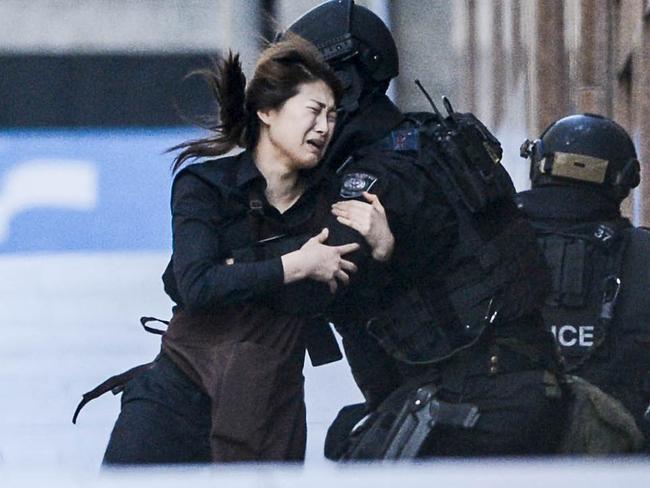 Hostage April Bae runs into the arms of police after escaping. Photos: Chris McKeen