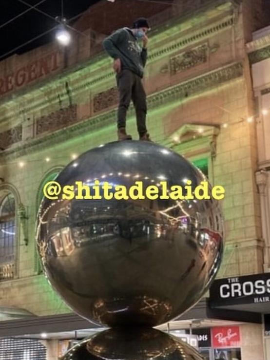 Man stands atop Mall’s Balls. Picture: JustAdelaideThings/ShitAdelaide Instagram