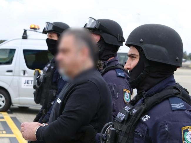 Officers from Strike Force Raptor hand Sam Ibrahim over to Australian Border Force.