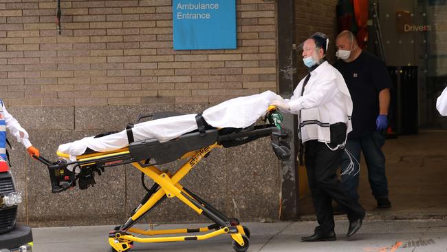 Health workers walk with a gurney outside Mount Sinai Hospital which has seen an upsurge of coronavirus patients in New York City. Picture: AFP