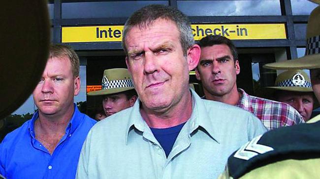 Bradley John Murdoch, centre, is surrounded by police as he arrives at Darwin airport after being extradited from Adelaide. Picture: AFP