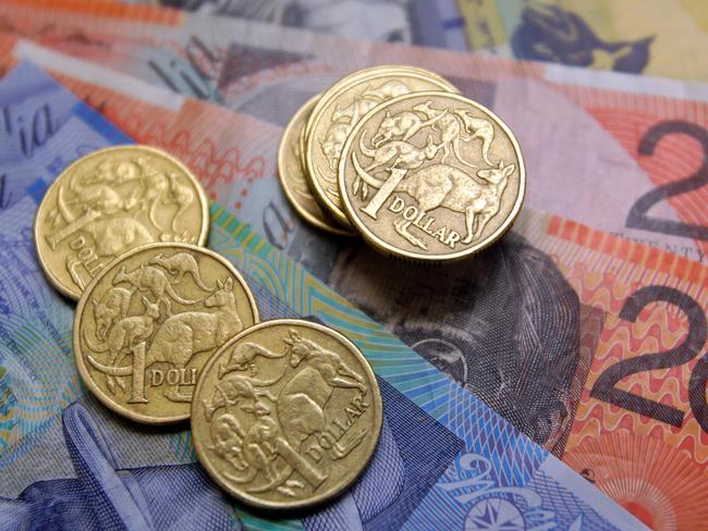 Australian one-dollar coins sit with a collection of bank notes arranged for a photograph, in Sydney, Australia, on Wednesday, Aug. 3, 2011. Australia's central bank may need to resume increasing the developed world's highest borrowing costs to keep inflation from accelerating as a mining boom intensifies, according to the International Monetary Fund. Photographer: Sergio Dionisio/Bloomberg